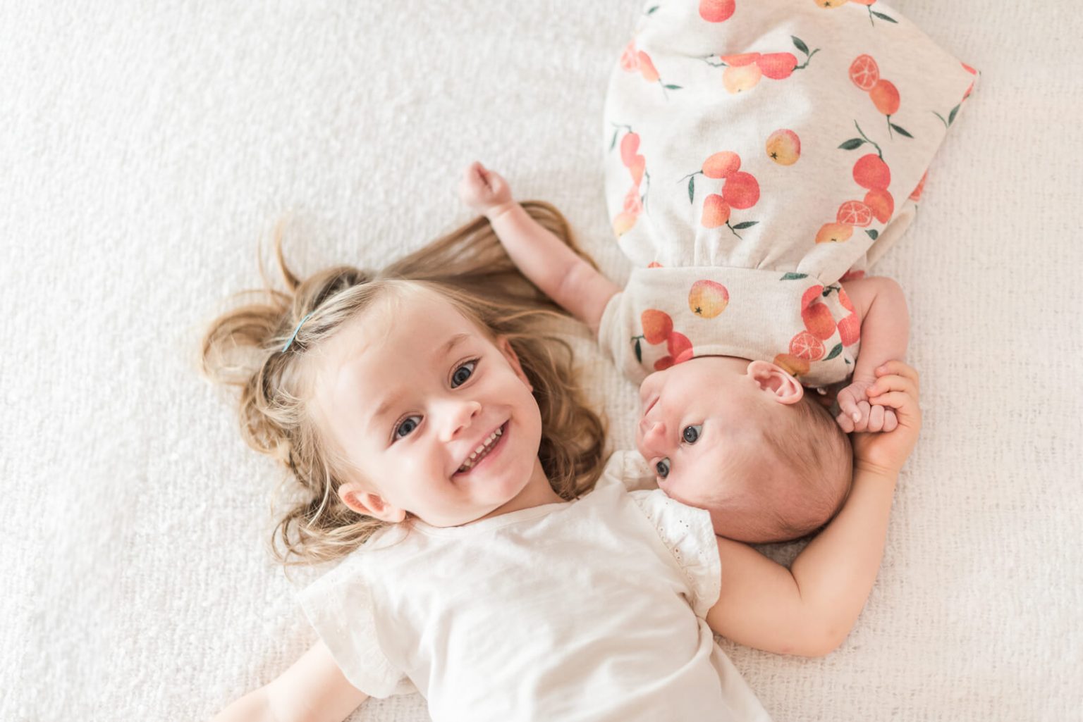 Photo de bébé et grande sœur lors d'une séance photo de naissance à domicile à Toulouse