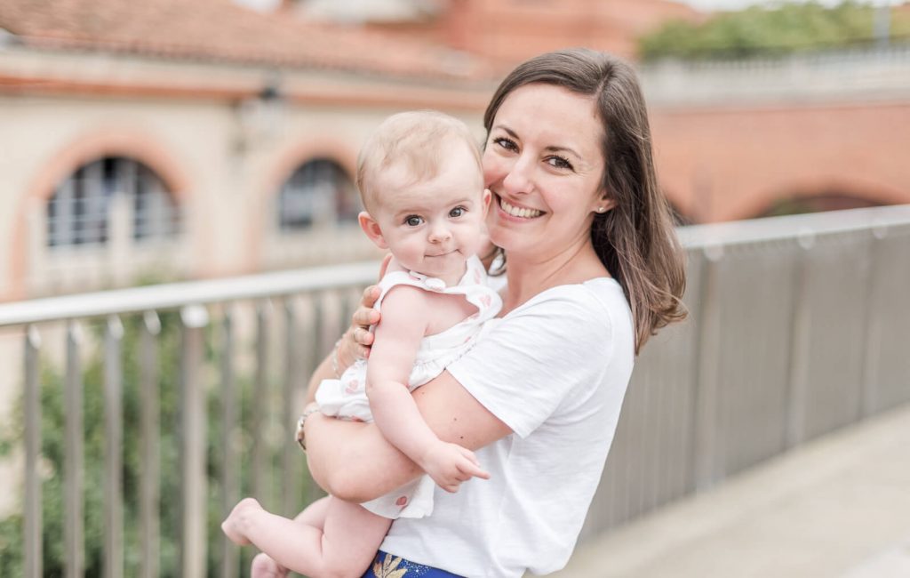 Photographe de famille à Toulouse sur les quais de la Garonne, portrait de bébé fille dans les bras de maman