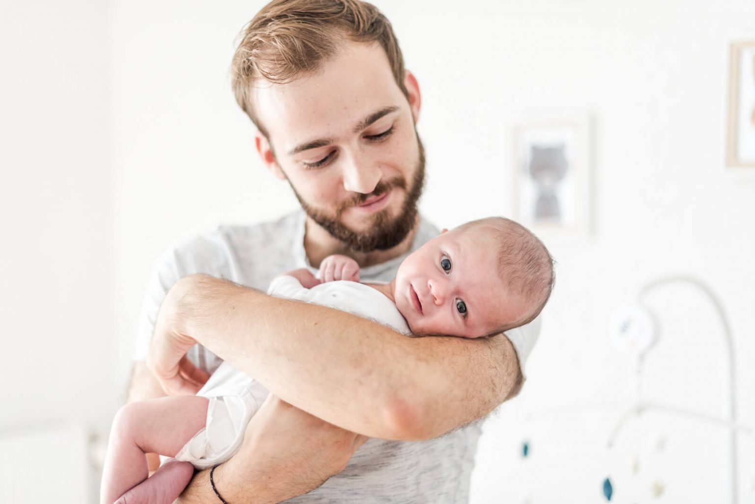 Photographe de nouveau-né à domicile à Toulouse, bébé dans les bras de papa
