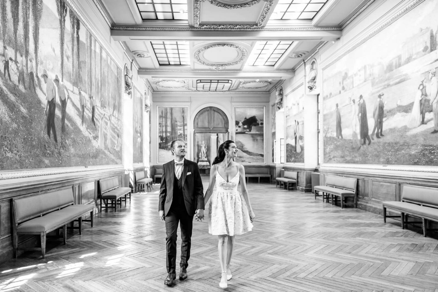 Photographe de mariage au Capitole de Toulouse - les mariés traversent la salle Henri Martin