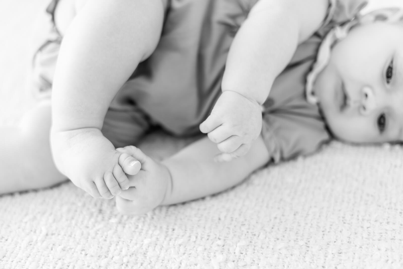 Photographe de naissance à domicile Montauban - photo de bébé de 4 mois qui joue avec ses pieds