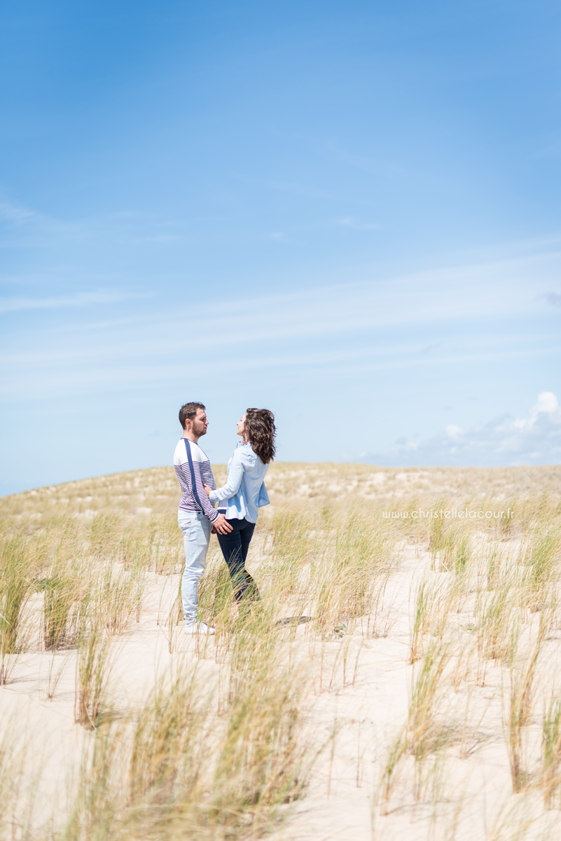 Deux amoureux seuls sur les dunes de l'Atlantique lors de leur séance love session