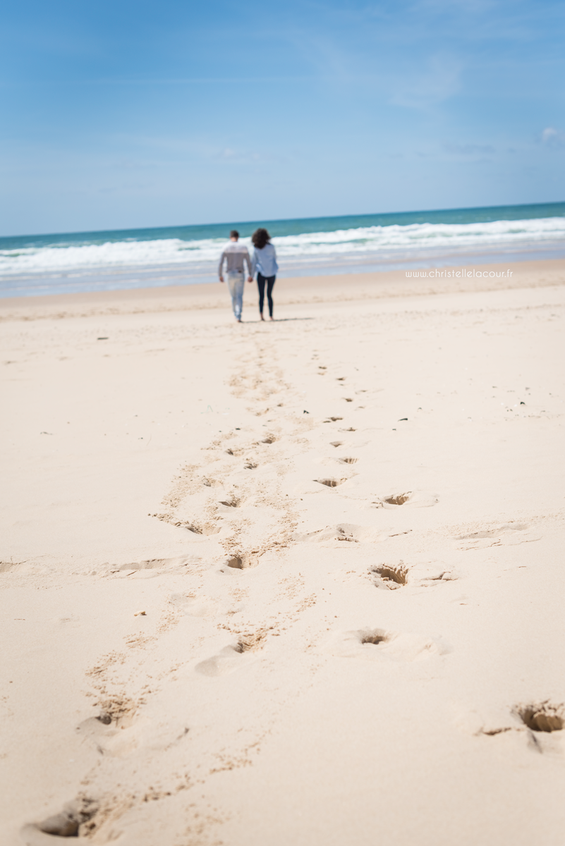Empreintes de pas dans le sable de Lacanau d'un joli couple lors de leur love session avec Christelle Lacour Photographe