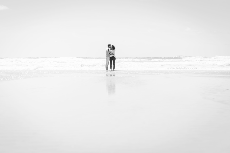 Amoureux s'embrassant les pieds dans l'eau sur la plage de Lacanau