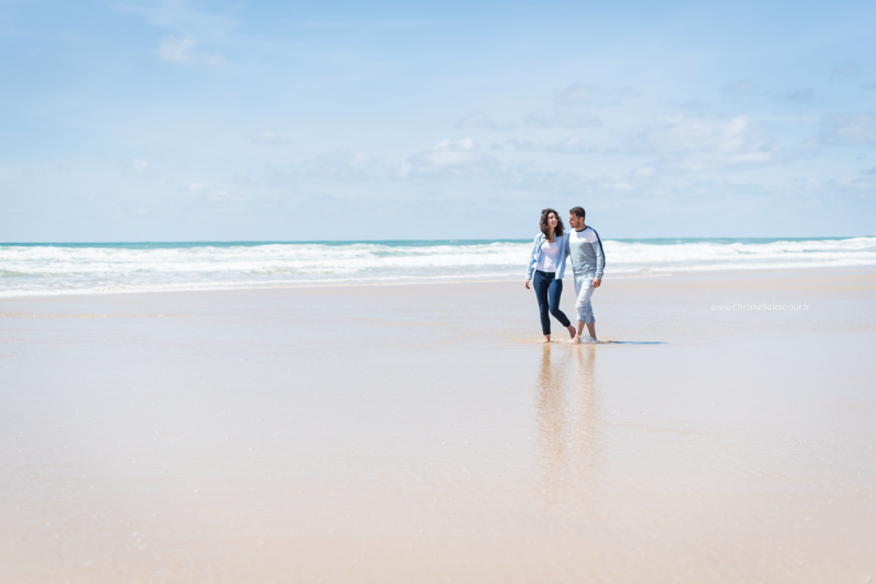 Photo couple sur la plage de Lacanau, amoureux marchant côte à côte les pieds dans l'eau