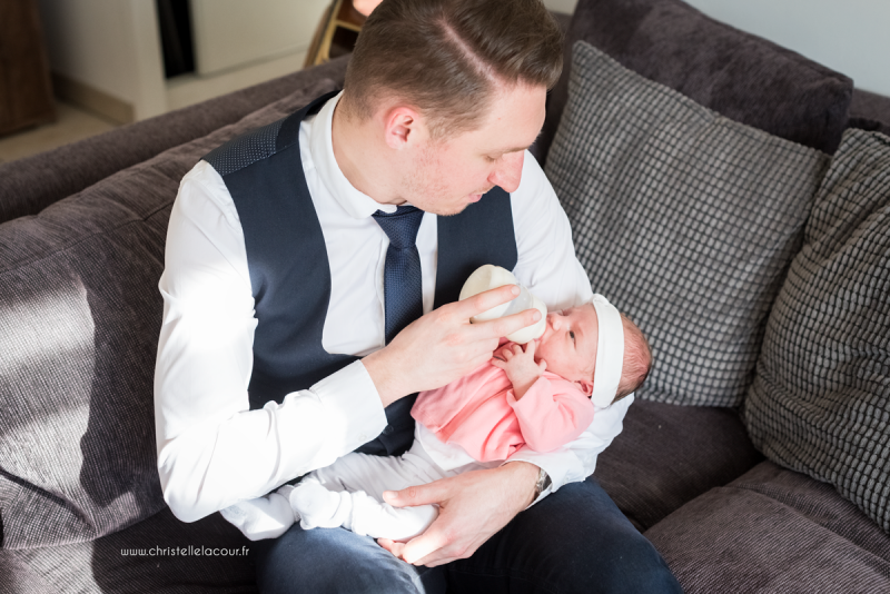 Photographe naissance lifestyle à Toulouse, la tétée dans les bras de papa