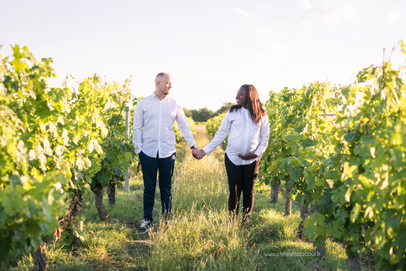 Photographe de grossesse à Toulouse, les futurs parents main dans la main dans les vignes de Fronton au coucher de soleil