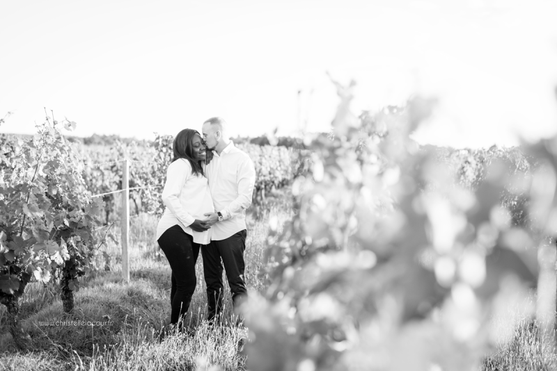 Photographe de grossesse à Toulouse, le bisou des futurs parents dans les vignes en noir et blanc