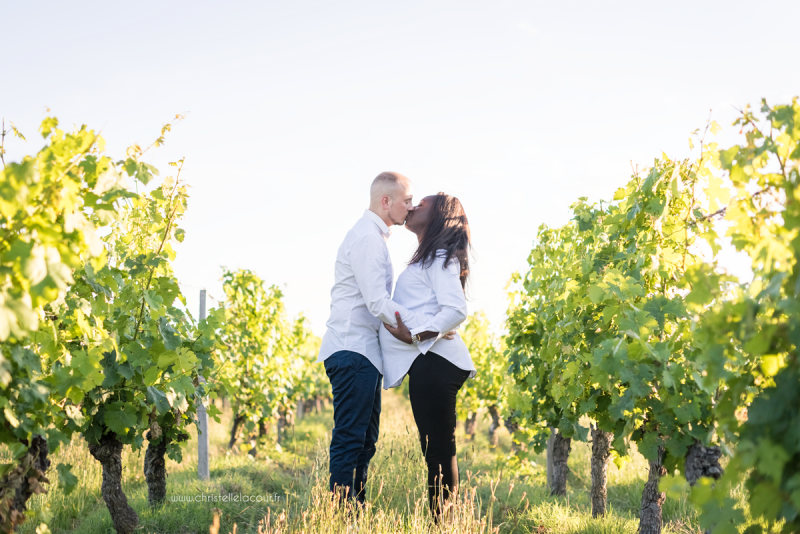 Photographe de grossesse à Toulouse, le bisou des futurs parents dans les vignes au coucher de soleil