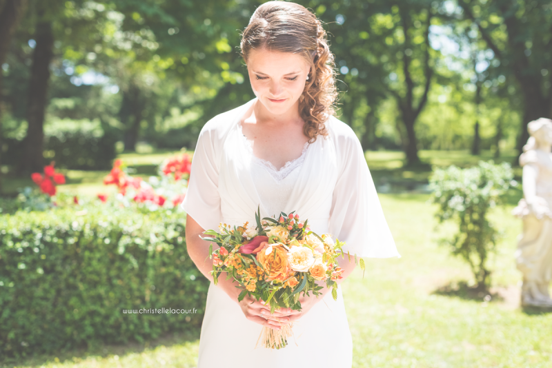 La mariée et son bouquet orange et coloré, mariage aux Arches de la Jinolié dans le Tarn