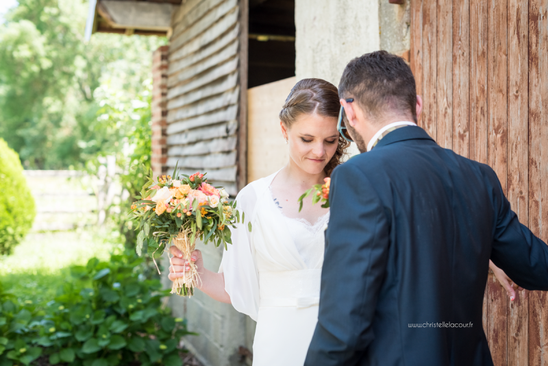 Photo de couple devant la porte de la grange, mariage fun et coloré aux Arches de la Jinolié dans le Tarn