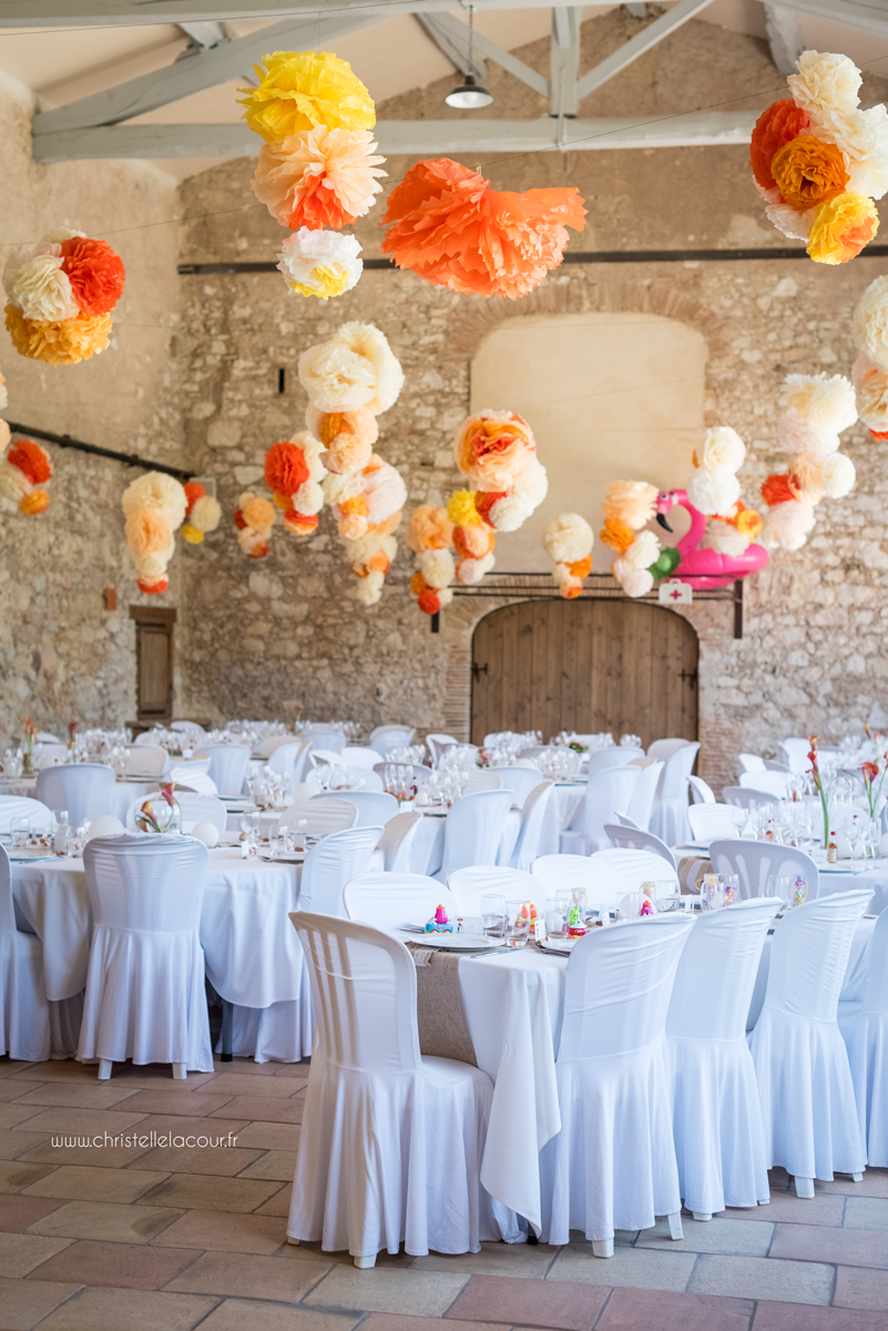 La décoration de la salle en pierres apparentes, orange, blanc, jute et dentelle, mariage fun et coloré aux Arches de la Jinolié dans le Tarn