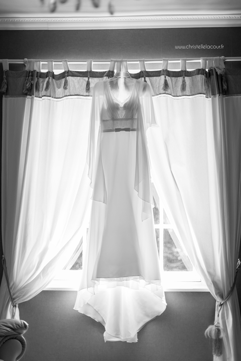 La robe de la mariée suspendue à la fenêtre, mariage fun et coloré aux Arches de la Jinolié dans le Tarn