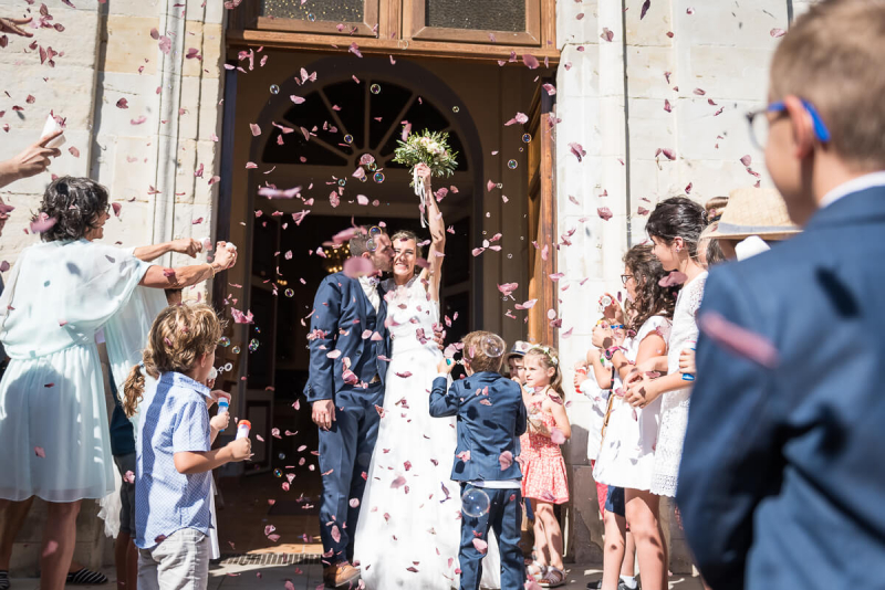 Sortie des mariés de l'église de Briatexte avec lancer de pétales de rose, mariage dans le Tarn, Christelle Lacour Photographe
