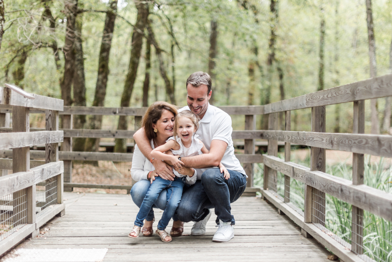 Photo d'une famille qui rit lors de sa séance photo de famille en forêt de Buzet près de Toulouse